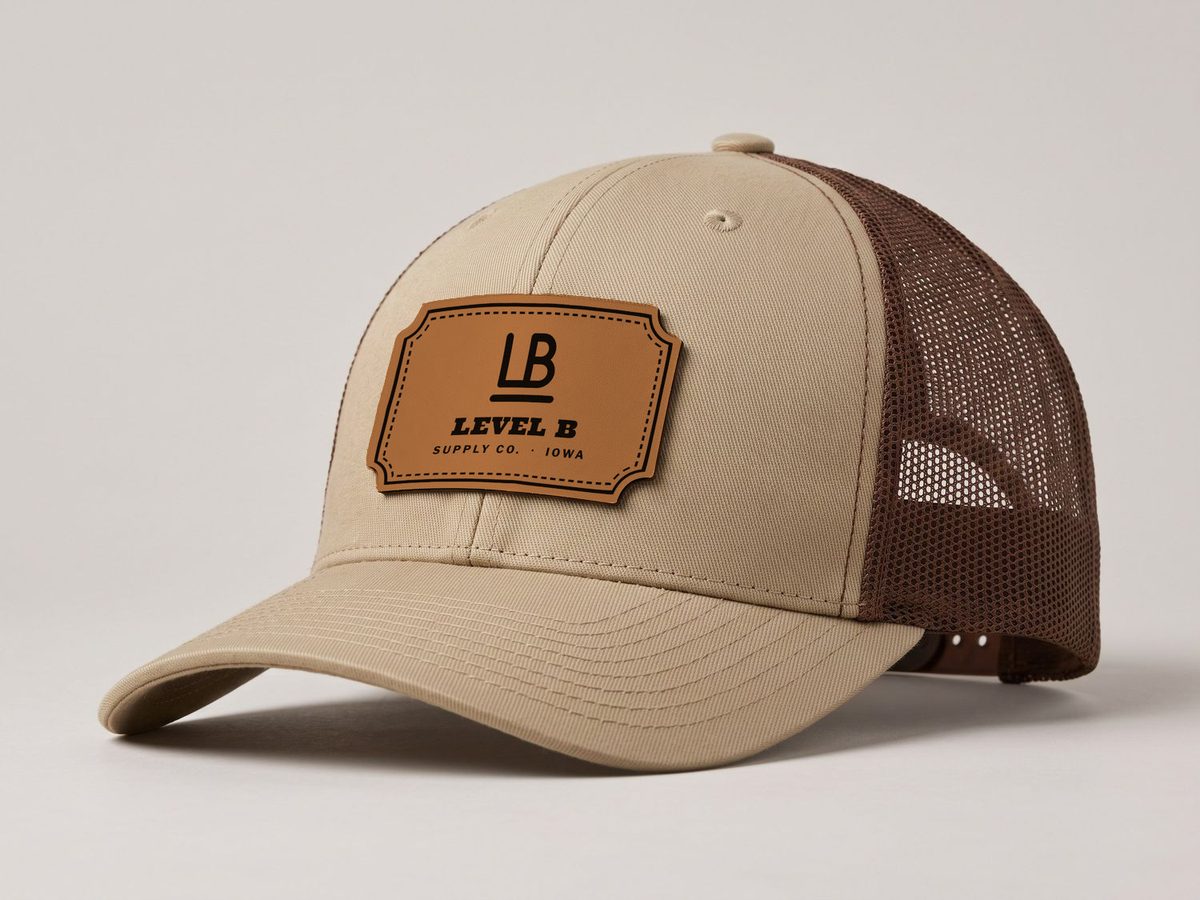 Khaki and coffee trucker hat with the Level B Rawhide leatherette patch
