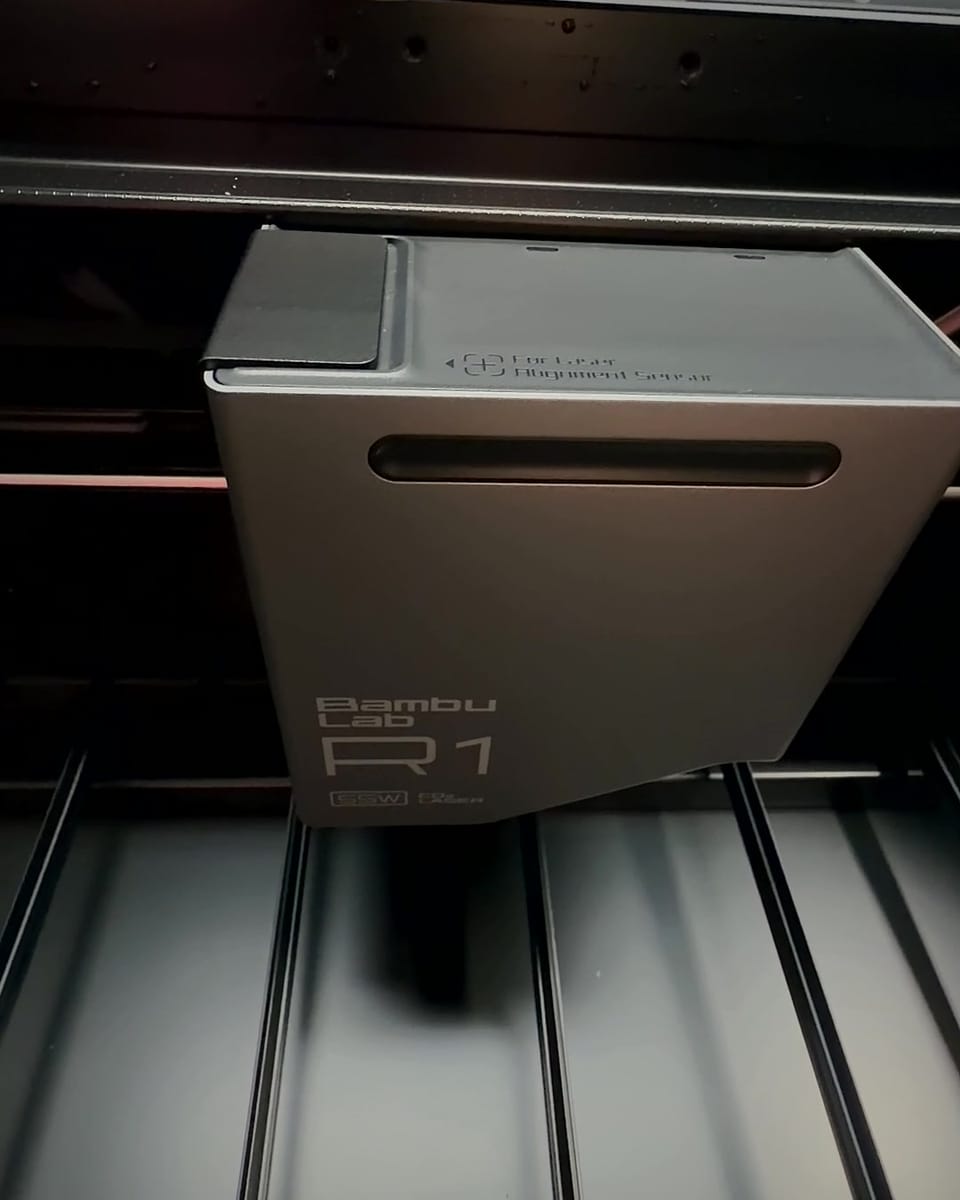 The laser head inside the Bambu Lab R1, with the lid open